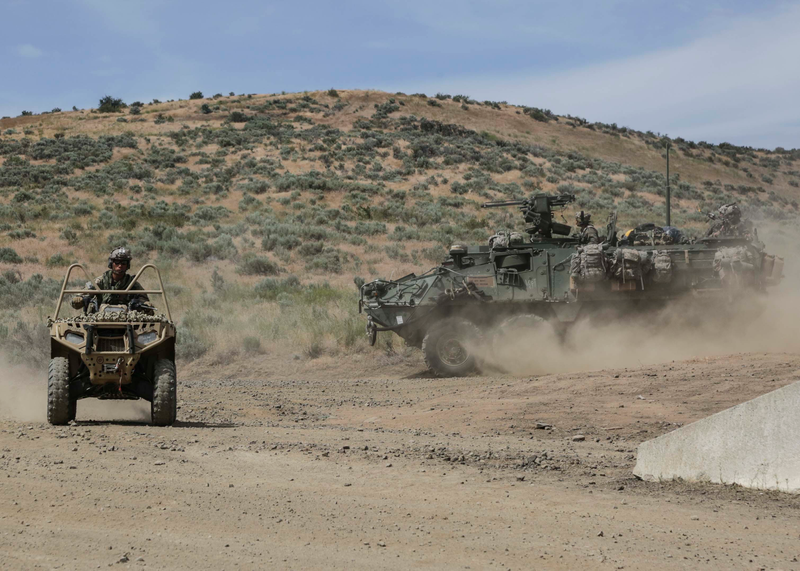 A Green Beret on a ATV assigned to the 1st Special Forces Group (Airborne) trains with a Stryker Interim Armored Vehicle from 2nd Stryker Brigade Combat Team.